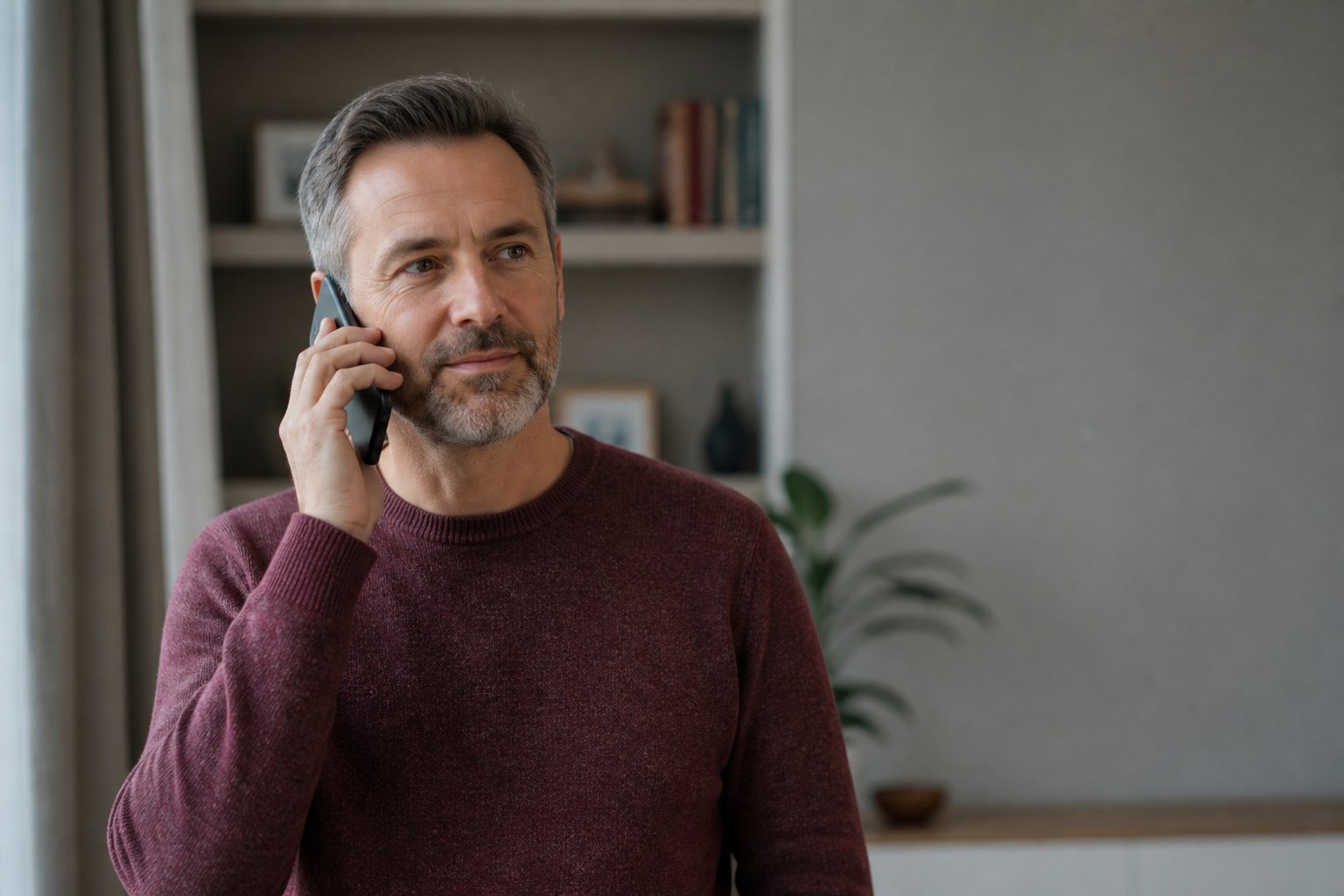 Ein Mann führt zu Hause ein gewöhnliches Telefongespräch.